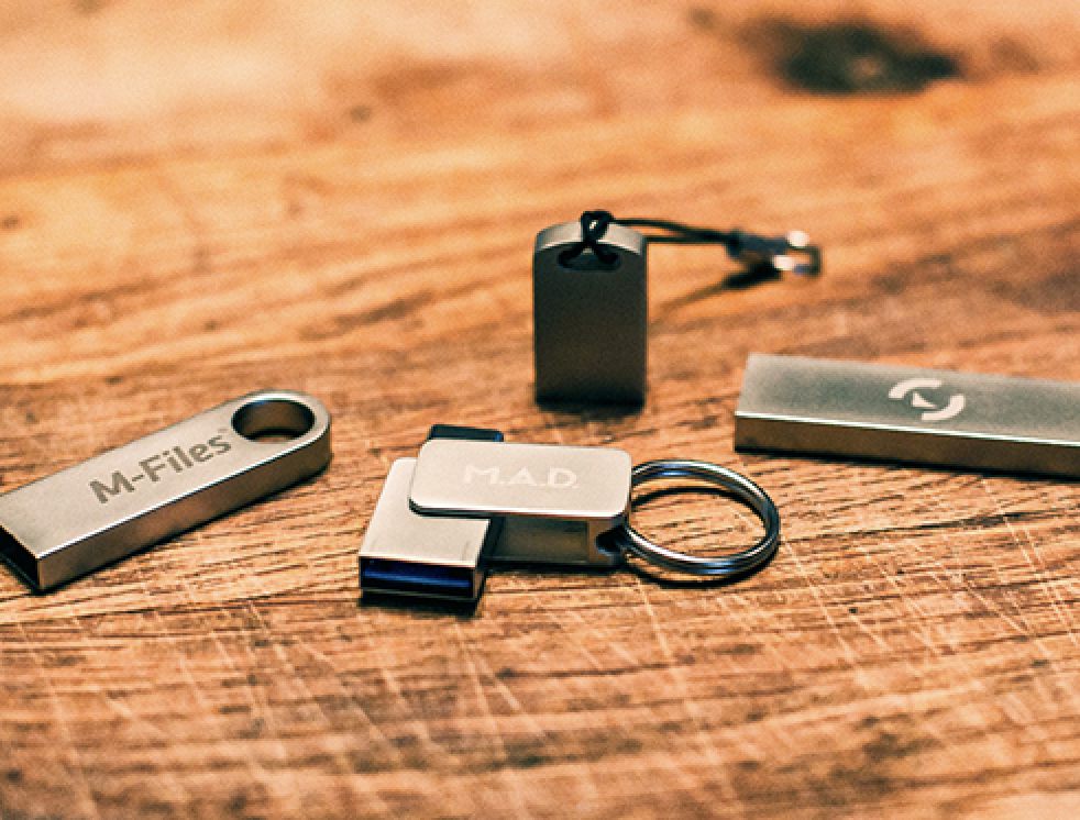 Metallinen USB-muistitikku kaiverrettuna omalla logolla
